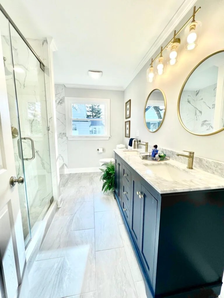 Navy vanity, marble top, and a glass shower