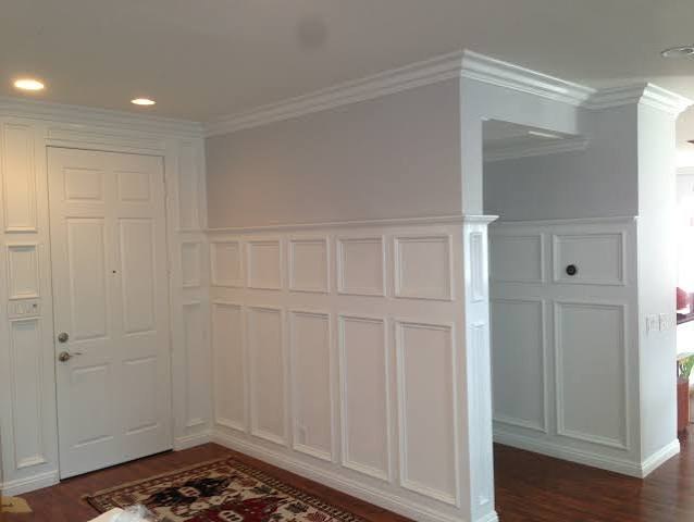 White raised-panel wainscot and crown in an entry
