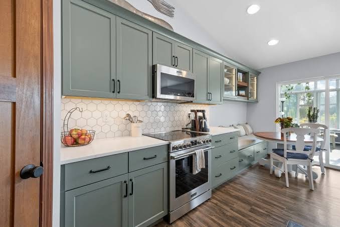 Sage cabinets, hex tile backsplash, and a white counter